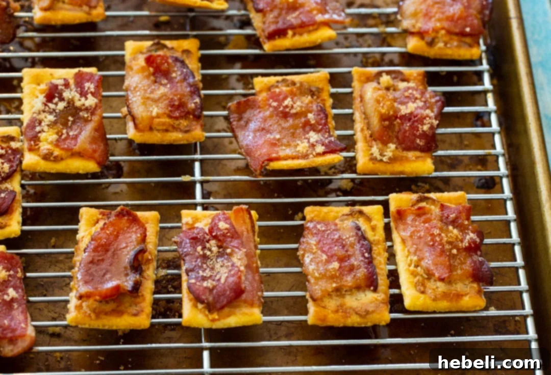 Bacon Boursin Cracker Bites 7 Freshly baked Boursin Bacon Crackers cooling on a wire rack after being removed from the oven, showcasing their irresistible golden-brown perfection and crunchy texture.