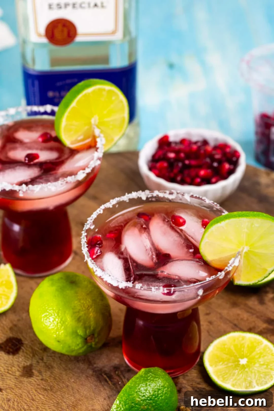 Perfect Pomegranate Margarita 3 Two Pomegranate Margaritas artfully presented in classic margarita glasses, showcasing their vibrant red hue.