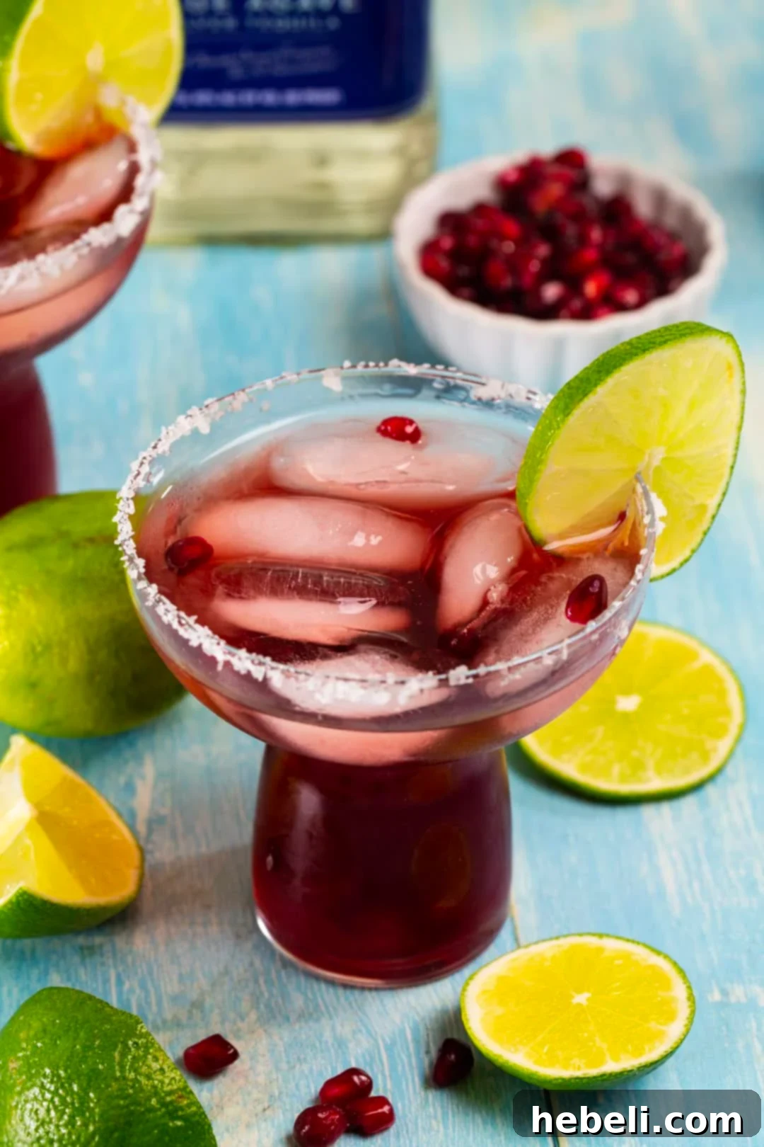 Perfect Pomegranate Margarita 4 A refreshing Pomegranate Margarita, elegantly surrounded by vibrant lime slices and scattered pomegranate arils.