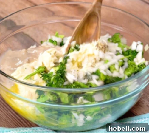 Large bowl showing broccoli, cream of mushroom soup, mayonnaise, butter, eggs, onion, salt, and pepper being whisked together.