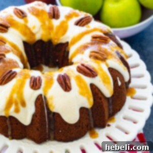 Finished Caramel Apple Pound Cake on a cake stand with generous drizzle.