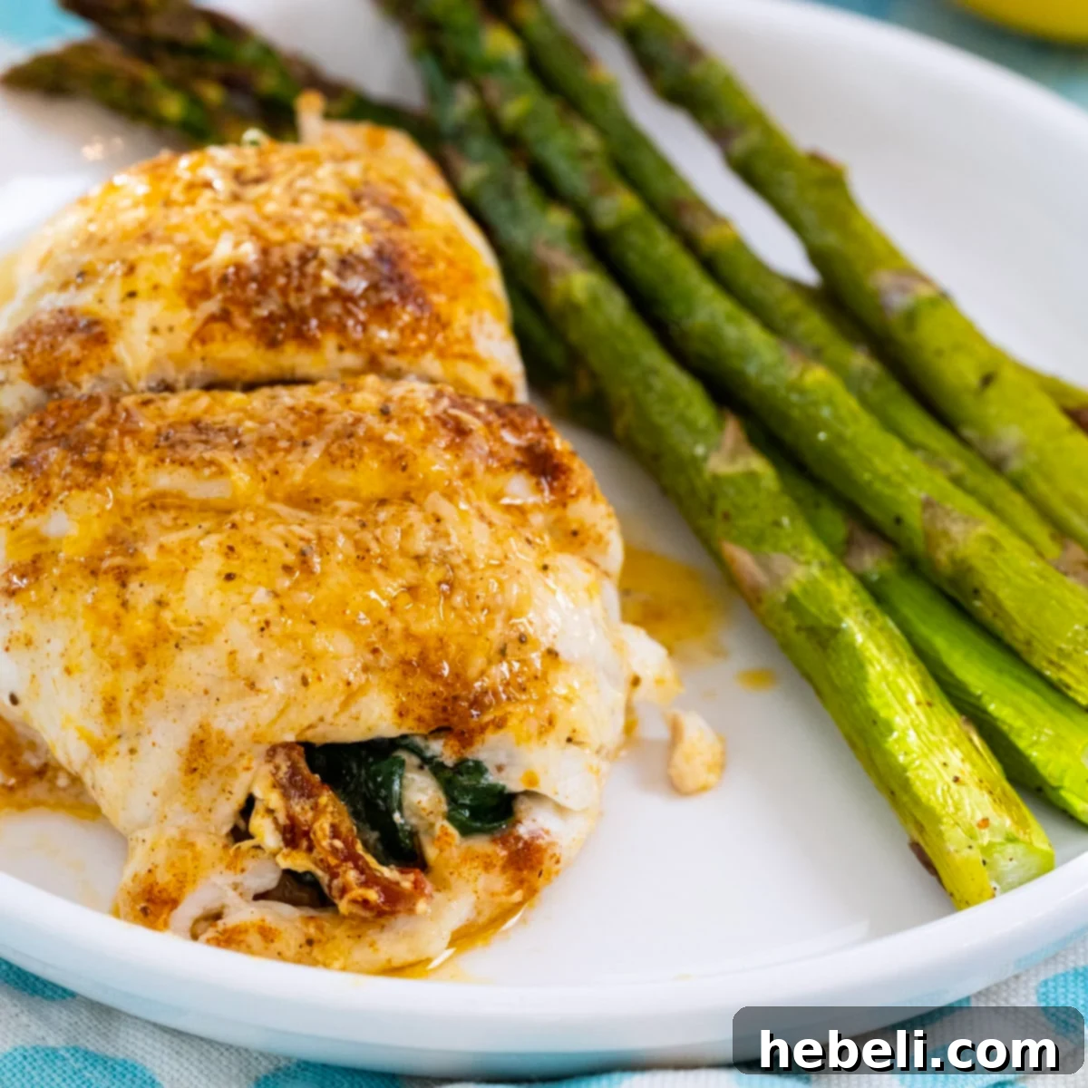 Flounder Fillets Stuffed with Creamy Spinach 2 Spinach Stuffed Flounder on a plate with asparagus, showcasing a beautifully baked fish dish.