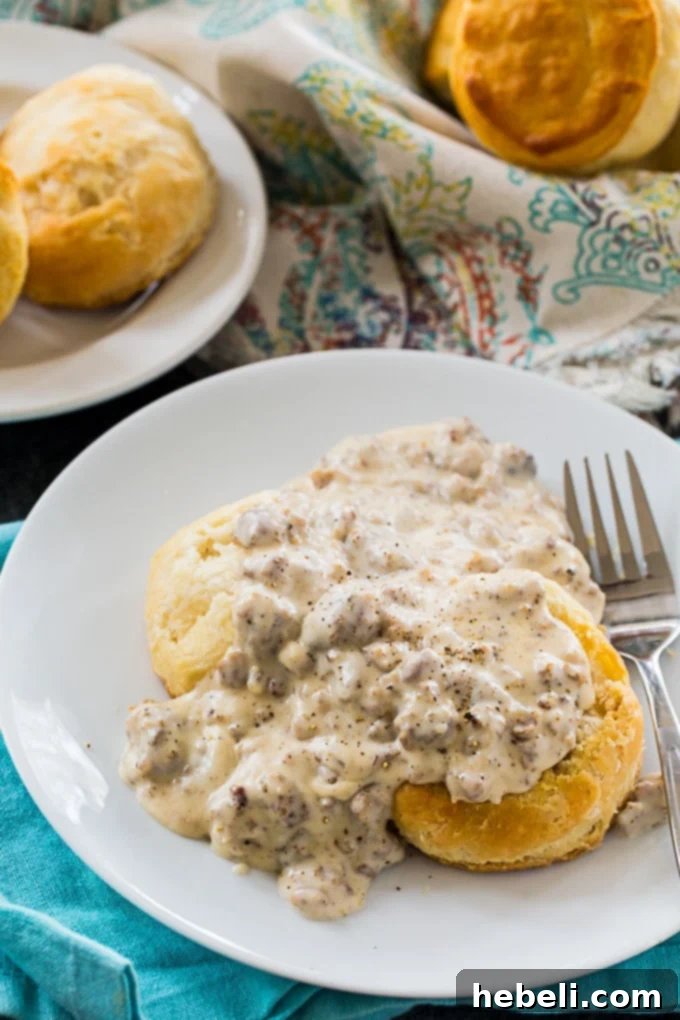 Easy Southern Sausage Gravy poured over fluffy biscuits.