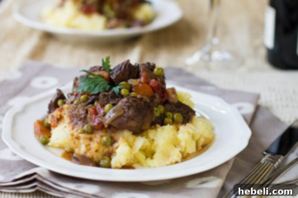 Effortless Slow Cooker Provencal Beef Daube 2 Hearty Slow Cooker Beef Daube served over creamy mashed potatoes on a rustic plate.
