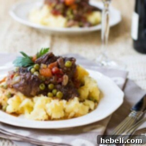 Effortless Slow Cooker Provencal Beef Daube 6 A beautifully presented bowl of Beef Daube Provencal, showcasing the rich sauce, tender beef, and colorful vegetables, topped with fresh herbs.
