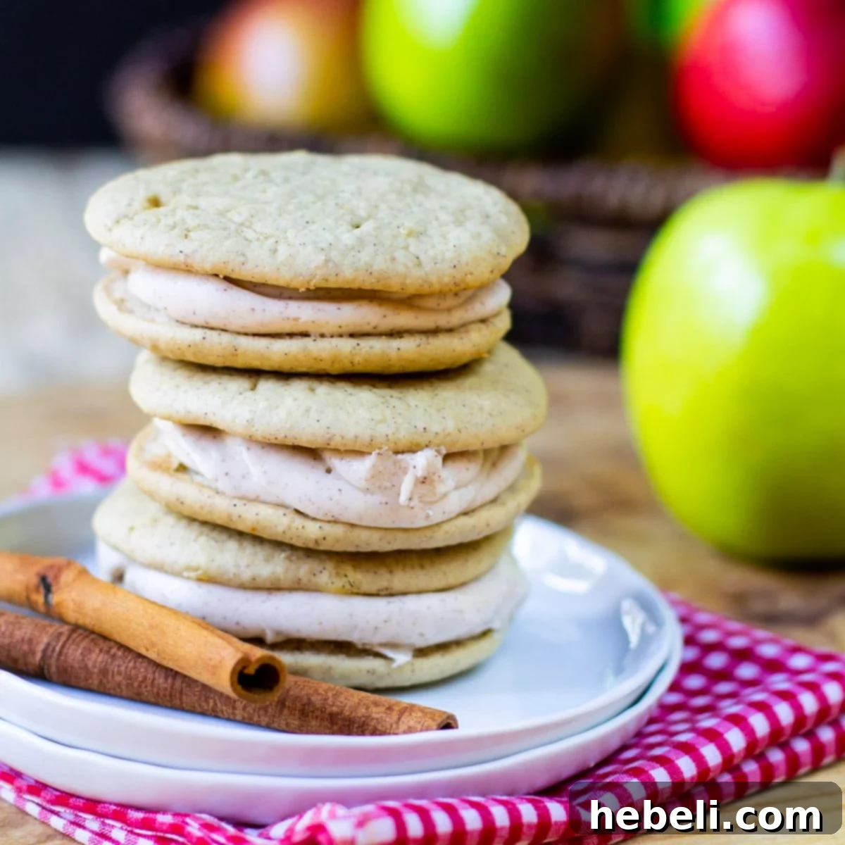 Spiced Apple Whoopie Delights 2 Stacked Apple Spice Whoopie Pies on a small plate, showcasing their soft, cake-like texture and creamy filling, ready to be enjoyed.