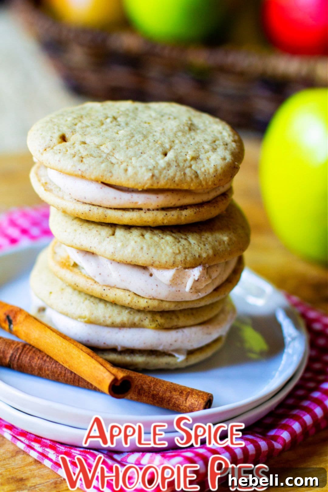Spiced Apple Whoopie Delights 5 A stack of golden brown Apple Pie Whoopie Pies on a white plate, ready for serving.
