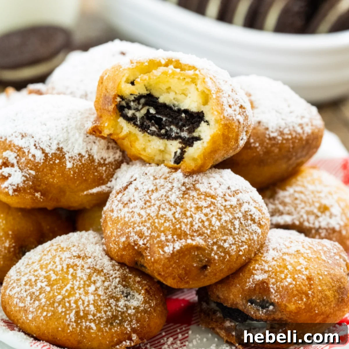 Oreo Fritters 2 Golden brown Fried Oreos dusted with powdered sugar, arranged beautifully on a plate, ready to be enjoyed.