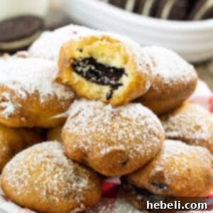 A plate of delicious fried Oreos, perfectly golden and dusted with powdered sugar.