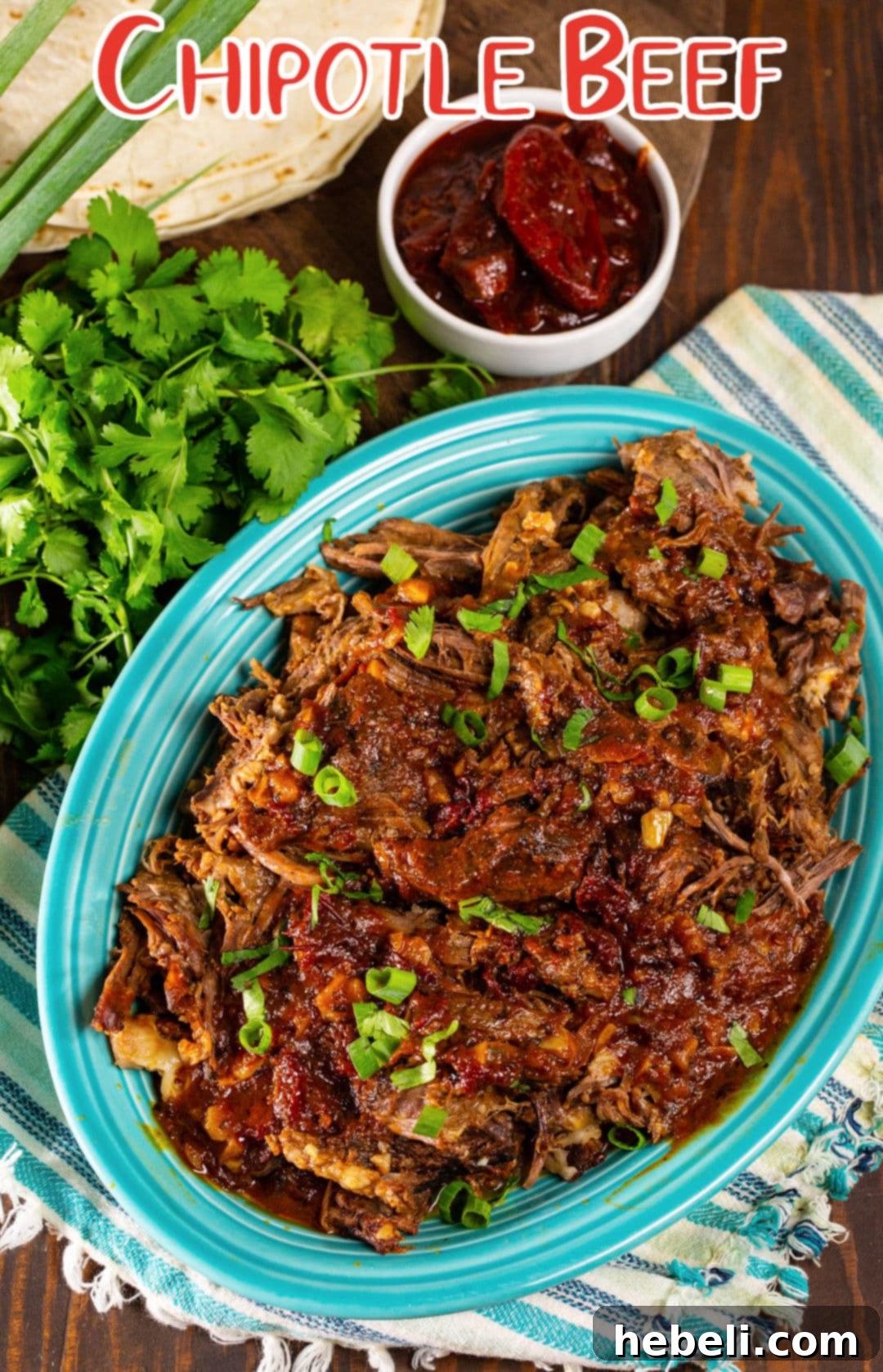 A hearty serving of Chipotle Beef for Tacos, accompanied by a small bowl of chipotle peppers in adobo, ready to add extra spice.