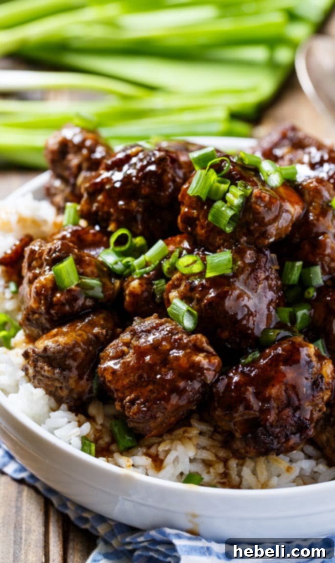 Fiery Apple Glaze Meatballs 2 Spicy apple-glazed meatballs served over a bed of fluffy white rice in a bowl, showcasing their delicious sauce.