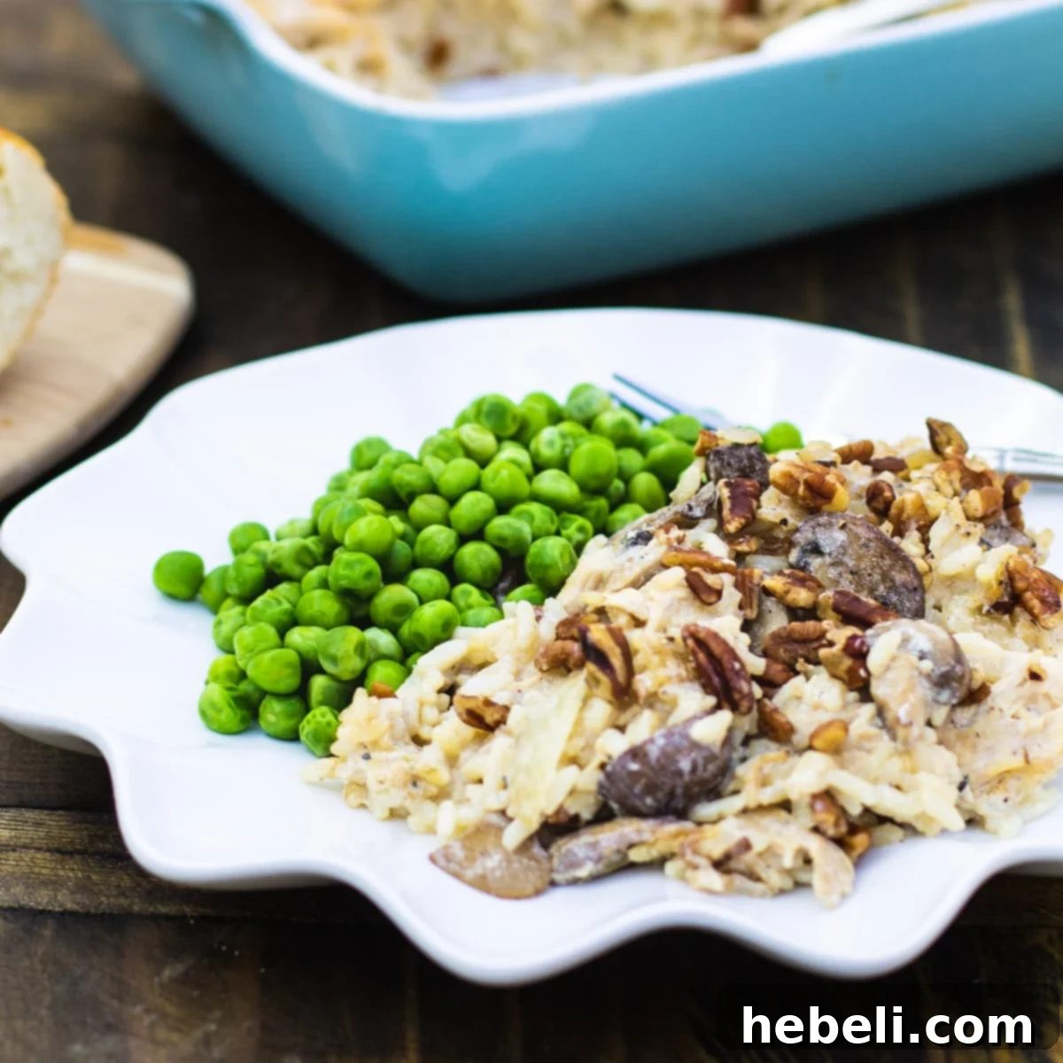 Creamy Chicken, Rice, and Mushroom Casserole on a plate with vibrant green peas, showcasing its rich texture and inviting warmth.