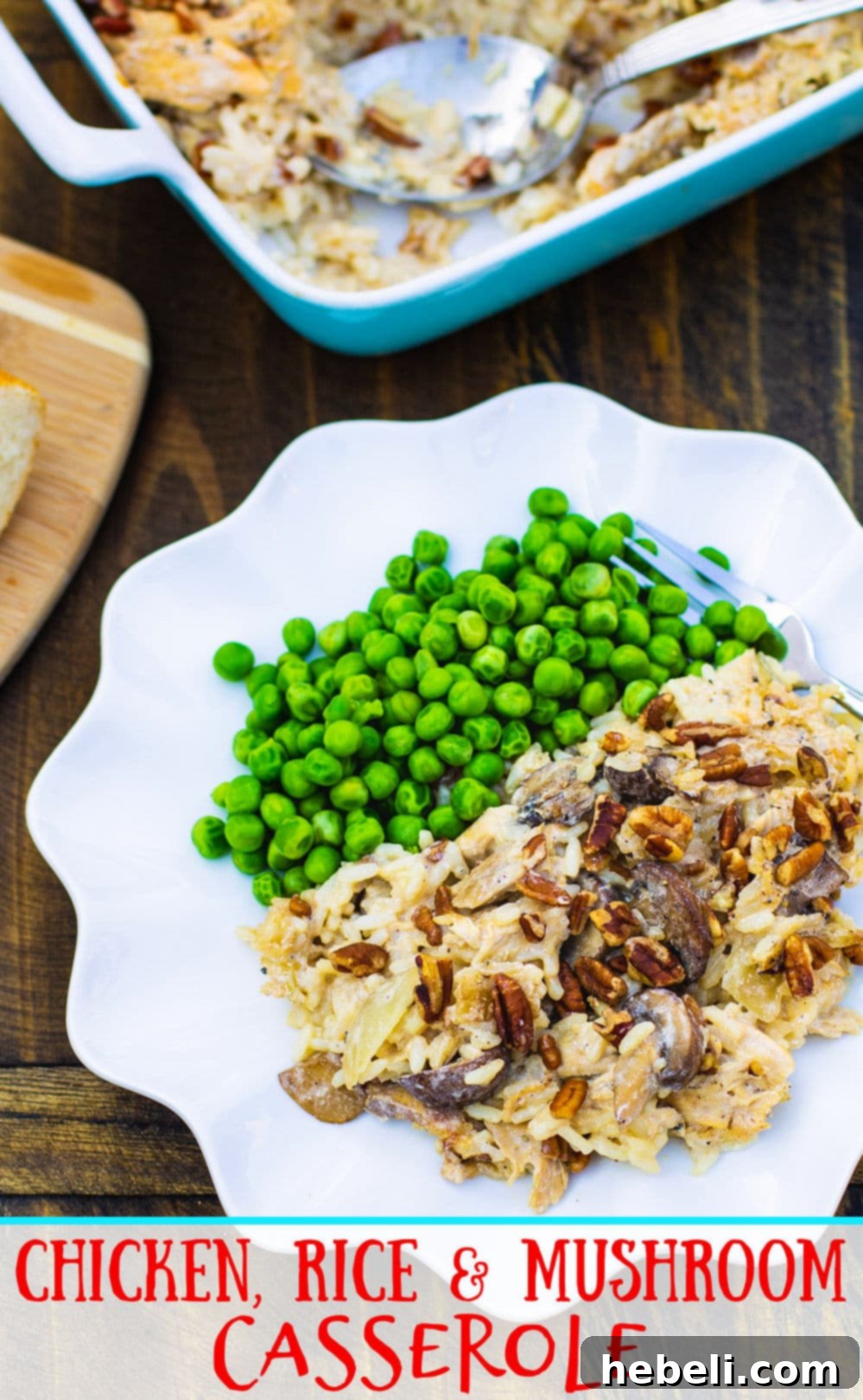A serving of creamy Chicken, Rice, and Mushroom Casserole on a white plate, accompanied by a vibrant side of green peas, presenting a complete and comforting meal.