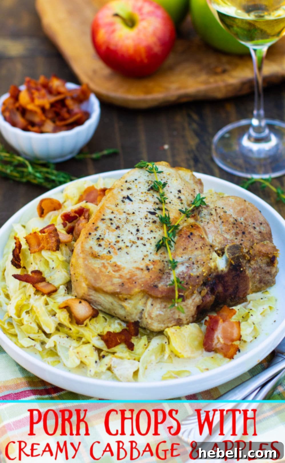 A single bone-in pork chop perfectly seared and roasted, served over a generous portion of creamy cabbage and apples.