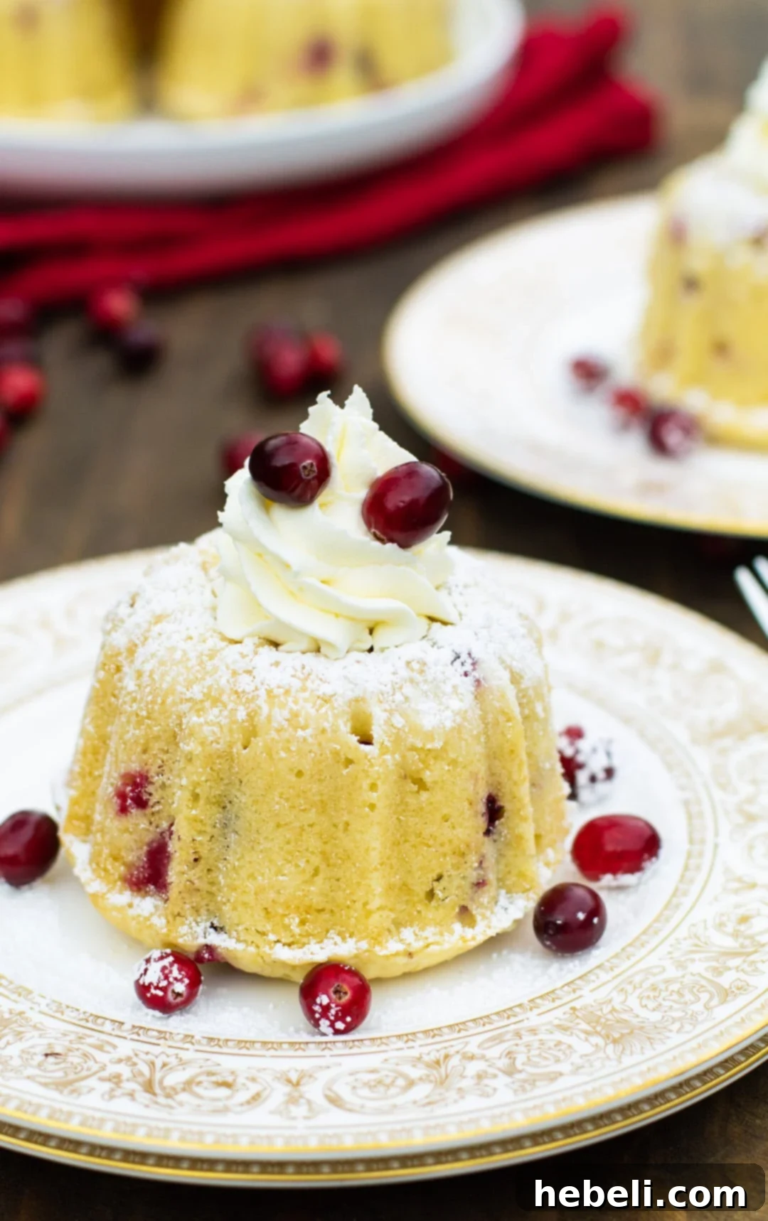 Almond Cranberry Cake with Mascarpone Frosting on a gold-plated plate, highlighting its rich, moist texture and generous frosting.
