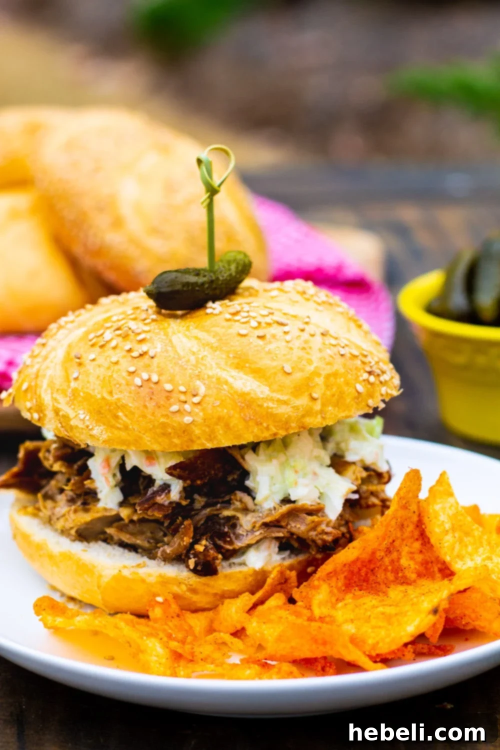 Slow Cooker 3-Ingredient Pork 3 Savory 3-Ingredient Pulled Pork served on a bun with crunchy potato chips