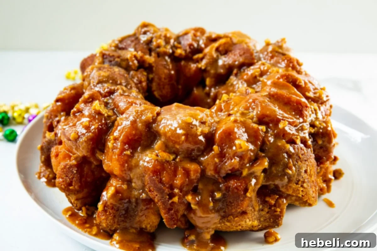 Mardi Gras Party Pull-Apart Bread 3 Unbaked Monkey Bread in a Bundt pan, coated in cinnamon sugar and pecans, before the butter glaze is added for baking.