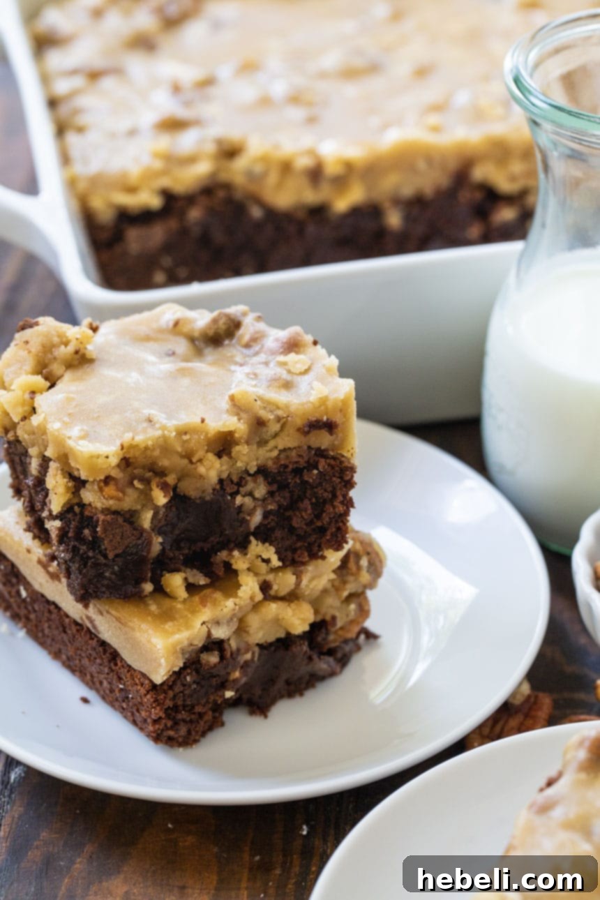 Two Praline Brownies stacked elegantly on a white plate, ready to be enjoyed.