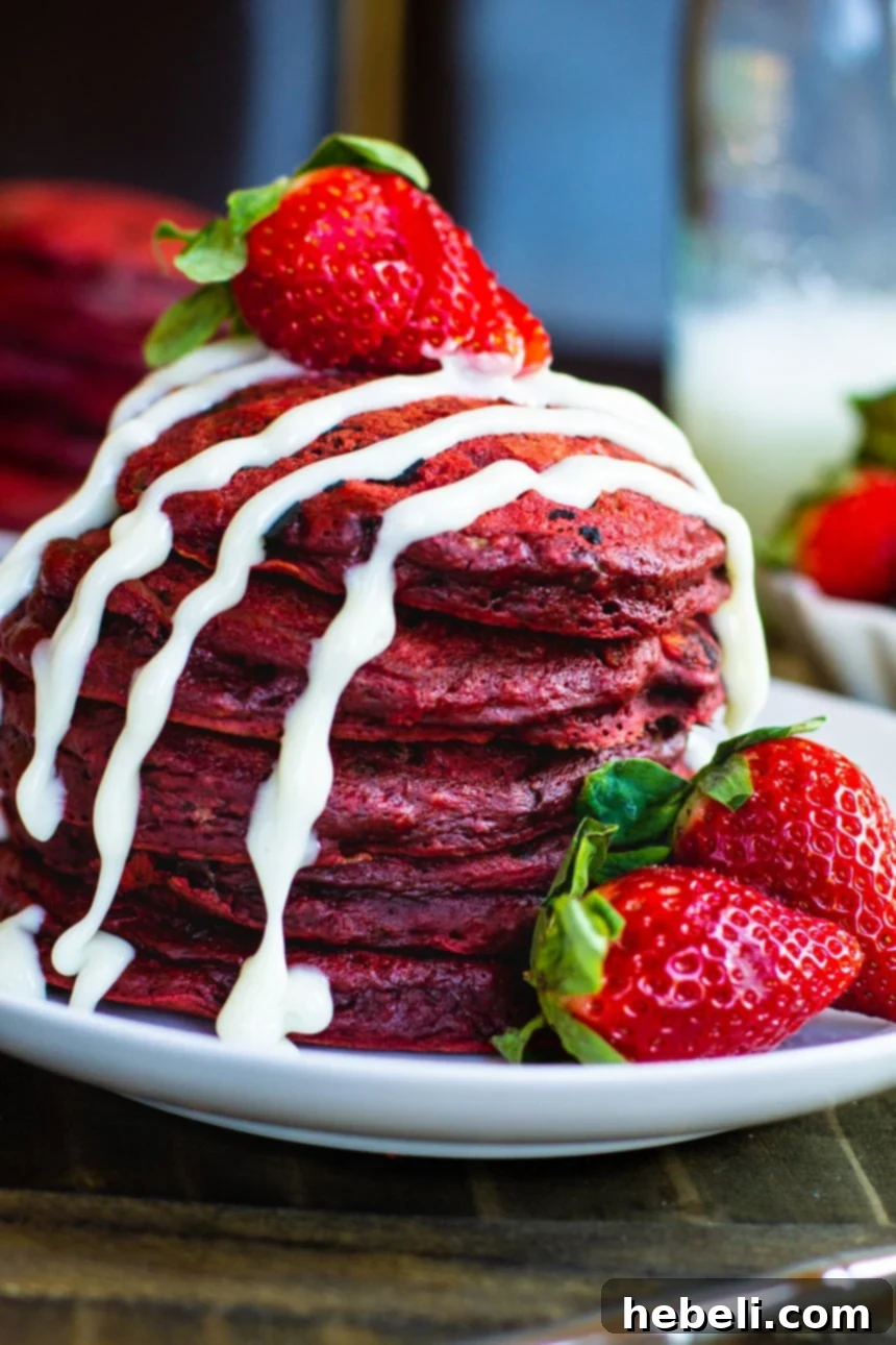 Red Velvet Pancakes with fresh strawberries and a cream cheese drizzle.