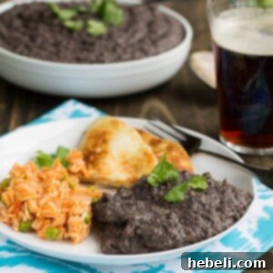 Smoky Homemade Refried Black Beans, a close-up view of the rich, dark beans.