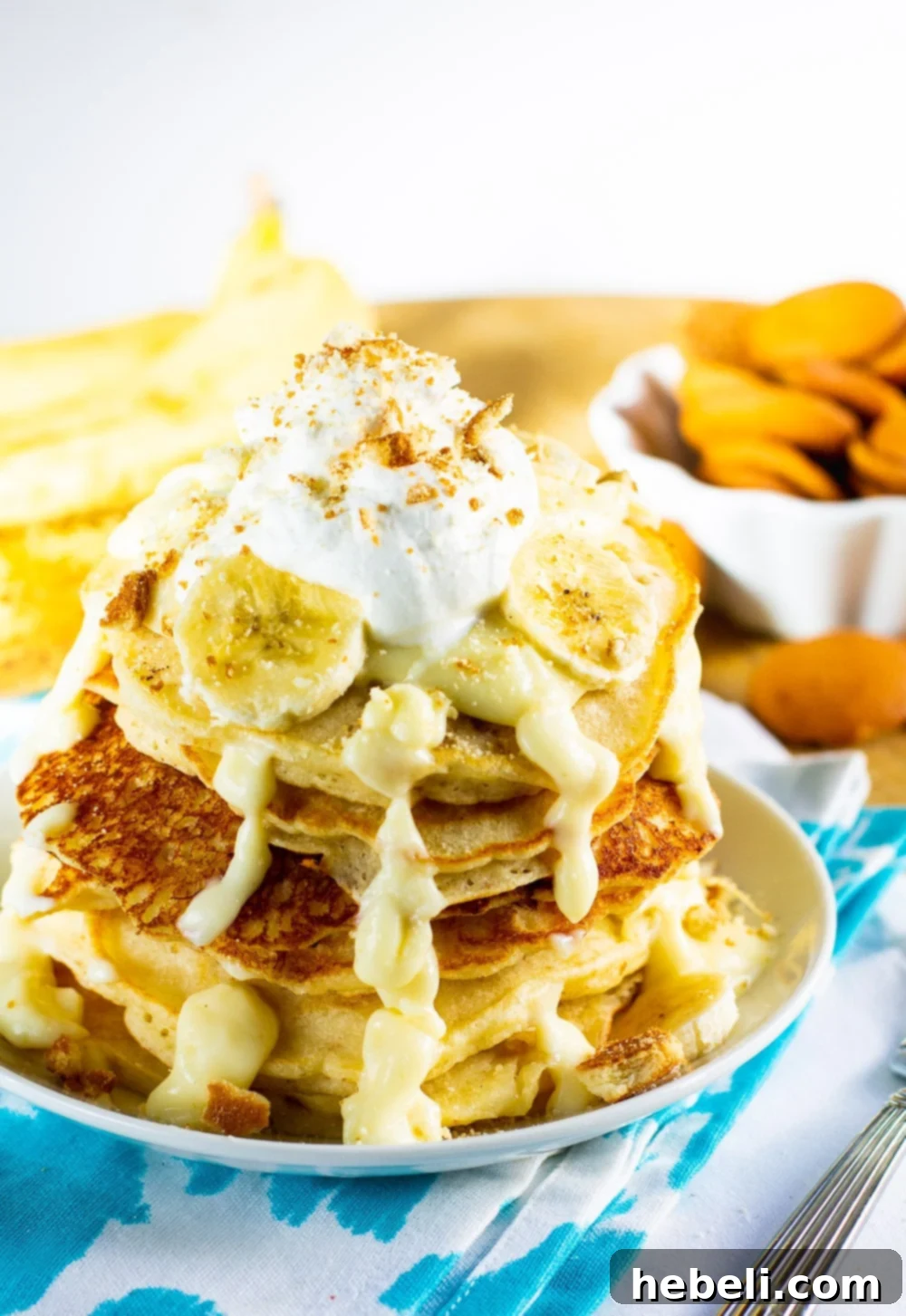 Decadent Banana Pudding Pancakes 4 Arrangement of cooked pancakes on a plate, with fresh banana slices and vanilla wafers scattered in the background, suggesting ingredients and toppings.