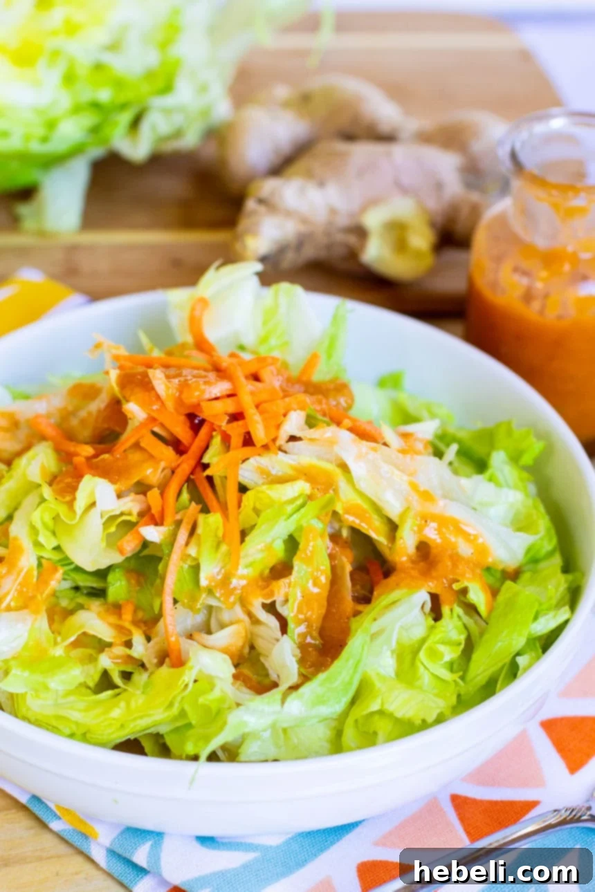 Zesty Ginger Vinaigrette 3 Close-up of a vibrant salad with fresh carrots, topped generously with homemade Japanese Steakhouse Ginger Salad Dressing.