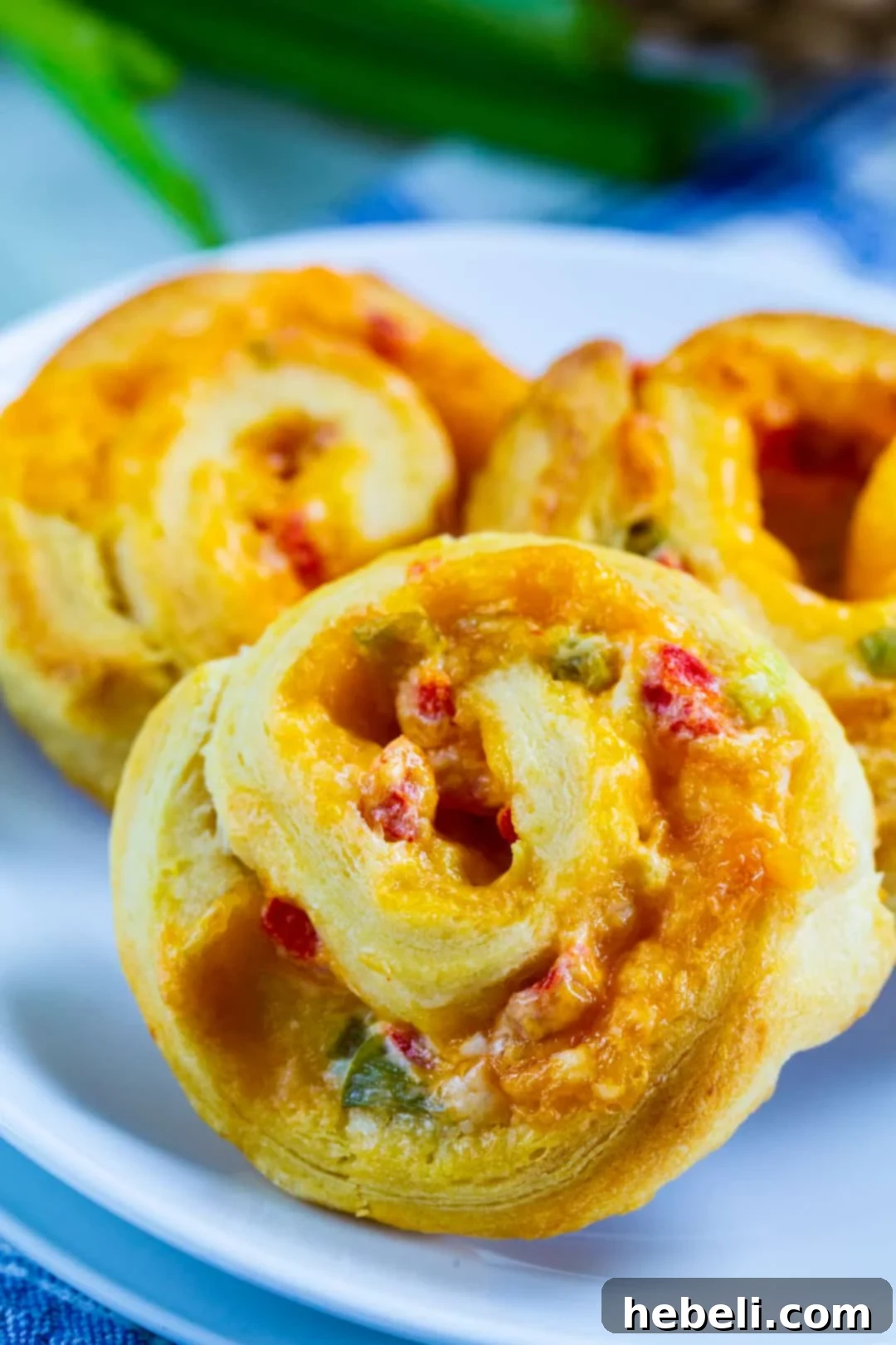 Close-up view of a Pimiento Cheese Spiral, showing the golden crust and vibrant pimiento cheese filling.