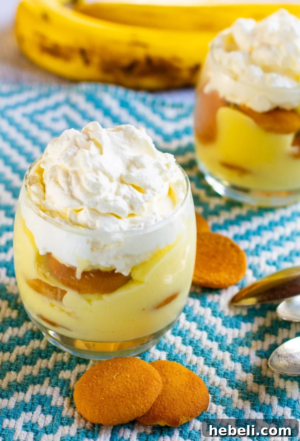Grandma's Best Banana Pudding 3 Two glasses of Homemade Banana Pudding with Nilla wafers arranged around them, showcasing the delicious layers.