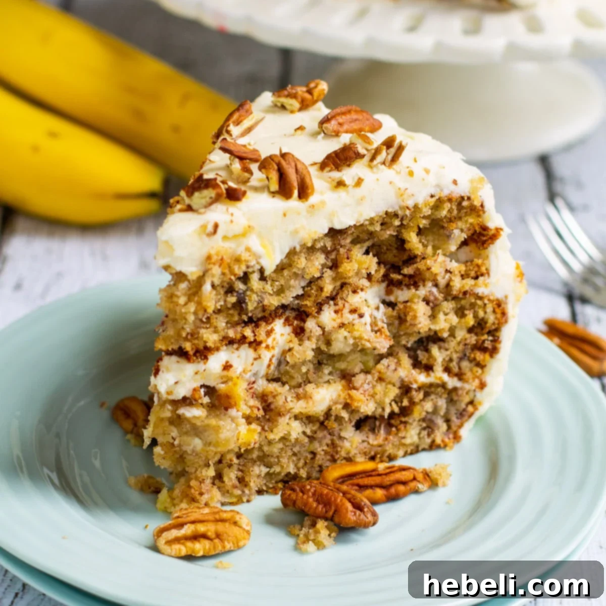 Banana Pineapple Pecan Paradise 2 A beautifully presented slice of Hummingbird Cake on a white plate, showcasing its moist layers and rich cream cheese frosting.