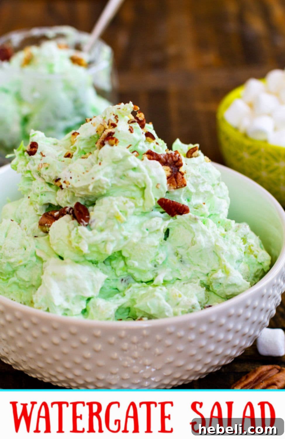 A close-up of Watergate Salad in a serving bowl, perfectly highlighting the fluffy texture of marshmallows, the juicy pineapple bits, and the crunchy pecans.
