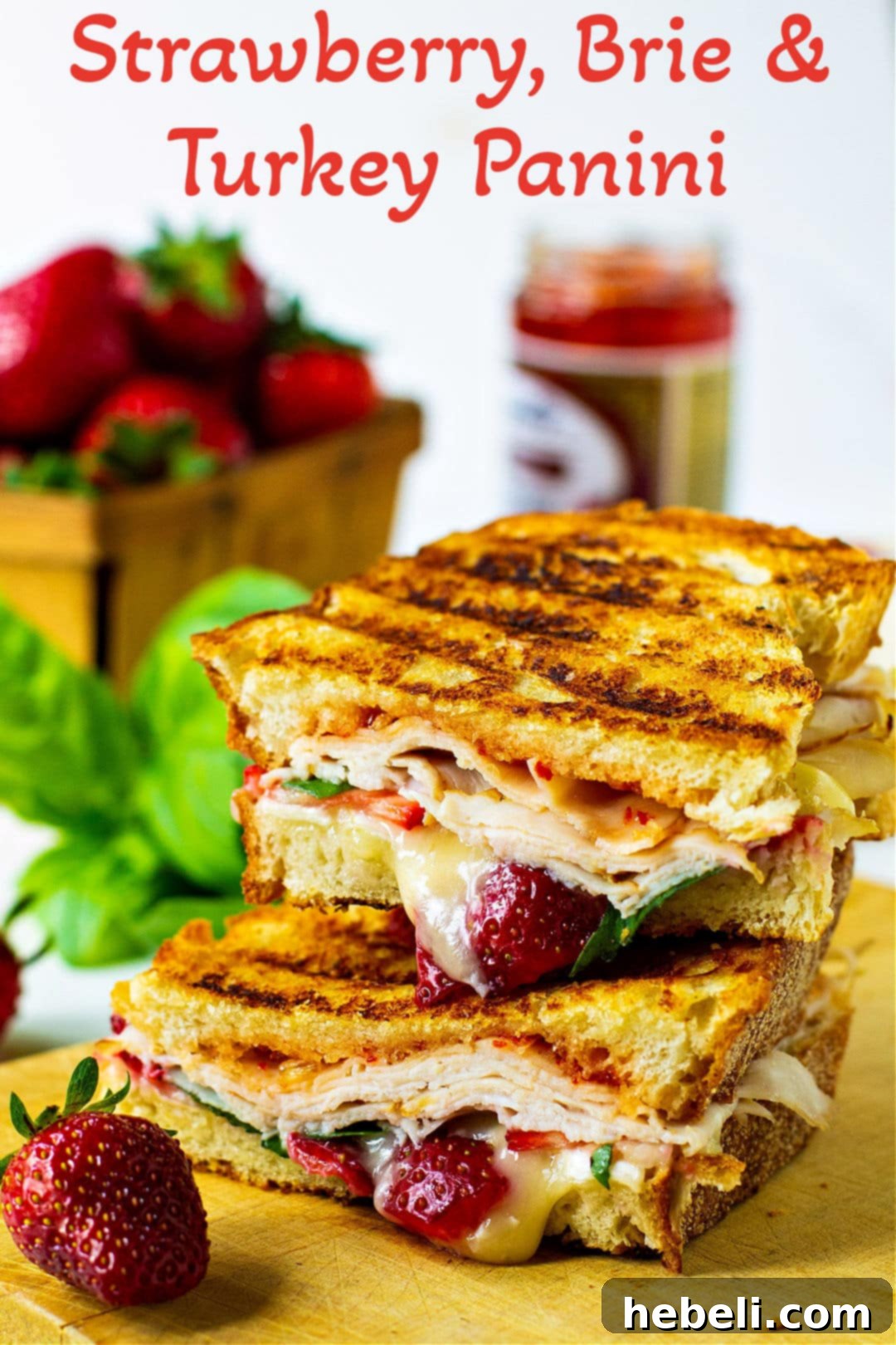 Panini sliced in half on a wooden cutting board, showcasing its perfectly grilled exterior and delicious fillings.