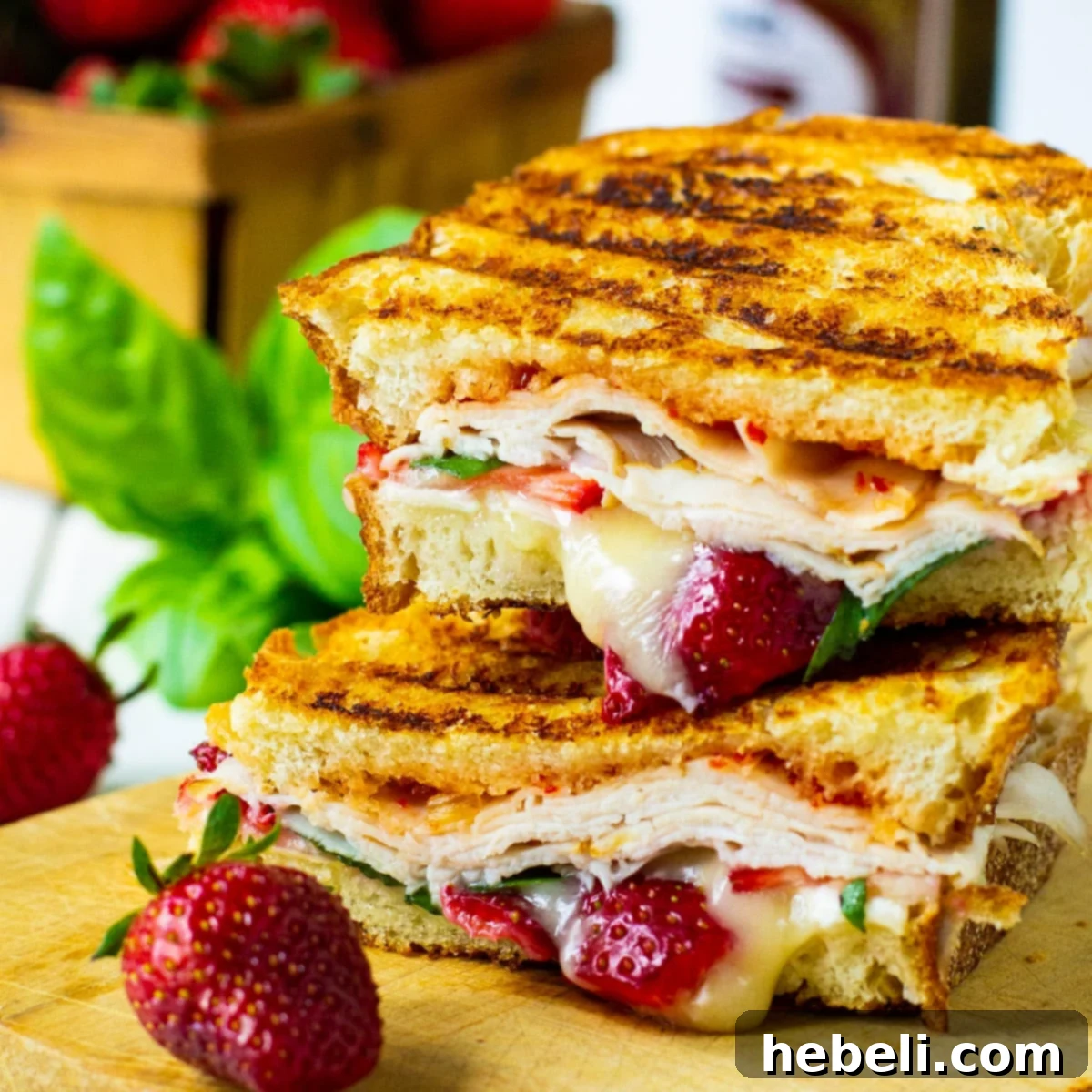 Strawberry, Brie, and Turkey Panini cut in half and stacked, showcasing the vibrant ingredients.