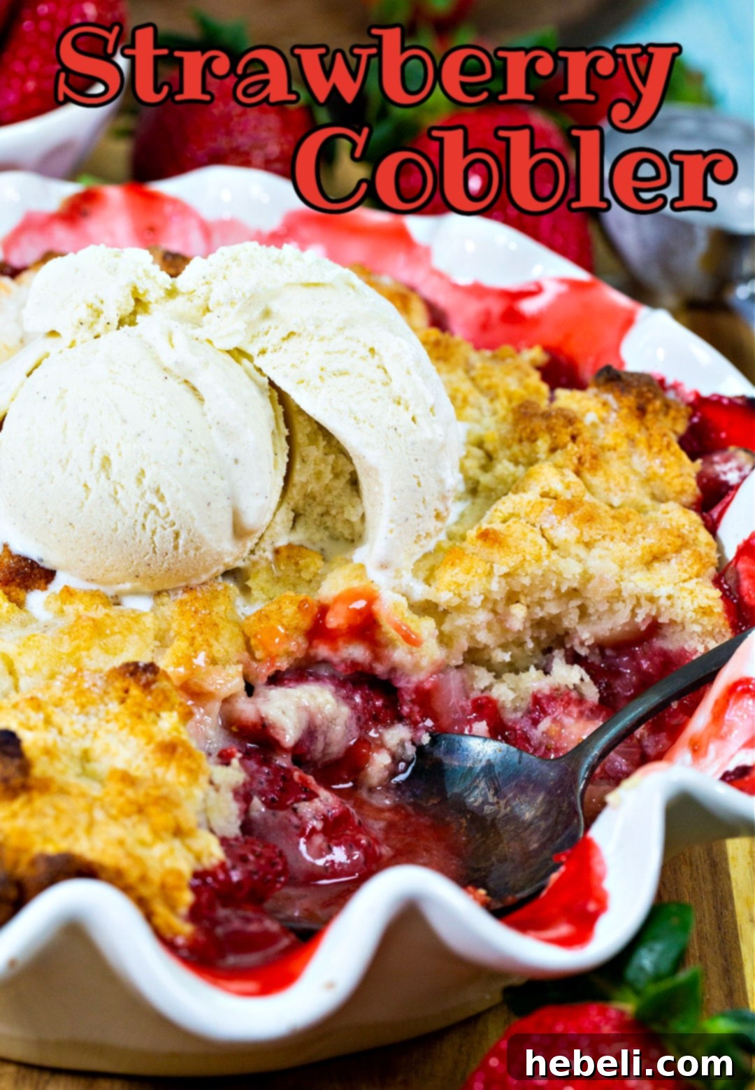 Strawberry Cobbler, glistening with fruit juices, topped with melting vanilla ice cream.