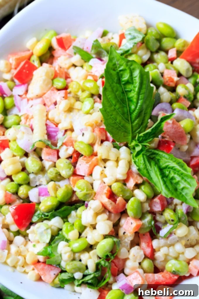Vibrant Roasted Corn and Edamame Salad 5 A bowl of Roasted Corn and Edamame Salad, garnished with fresh basil leaves.