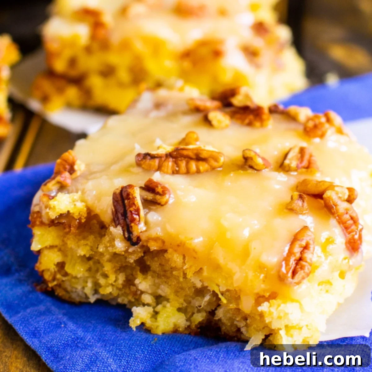 Close-up of a perfectly sliced Pineapple Sheet Cake, revealing its moist texture and coconut-pecan topping.