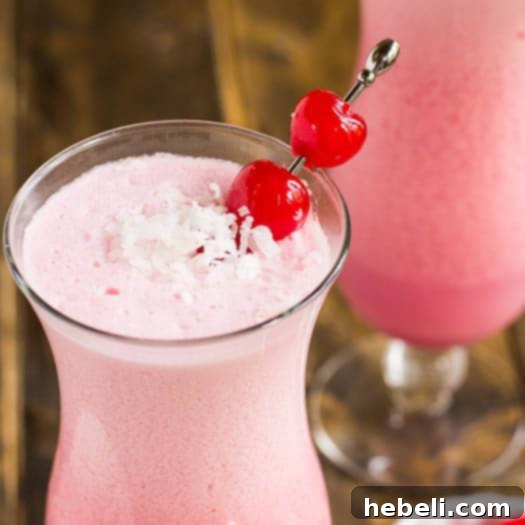 Pink Coconut Frost Cocktail ready to serve in a tropical setting