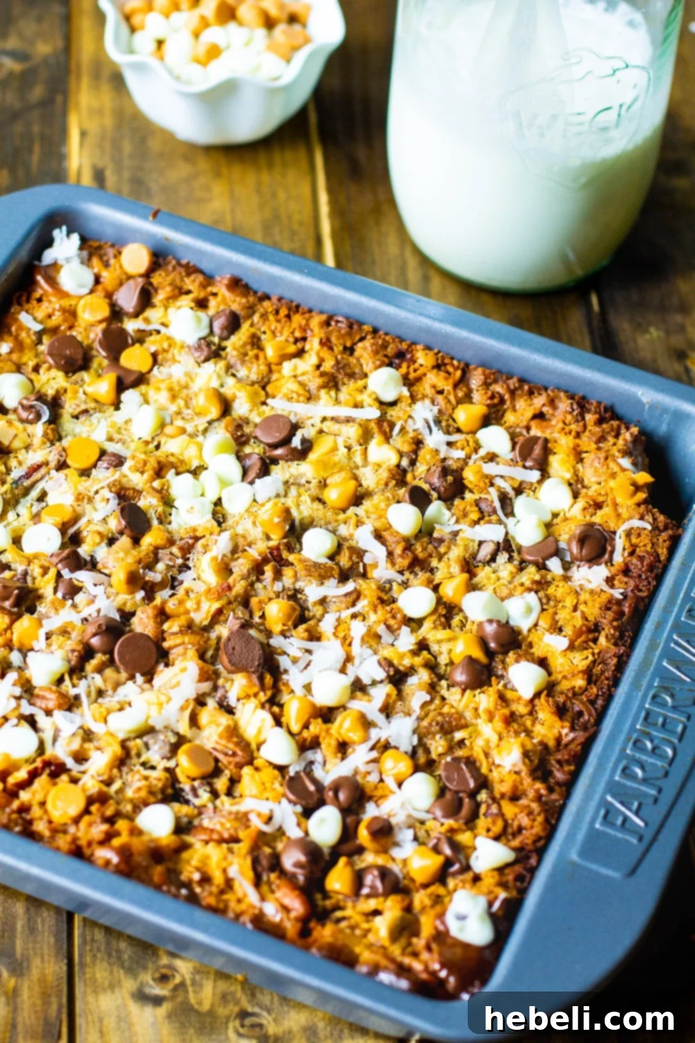 Magic Bars in a baking dish, glistening and golden brown after baking.