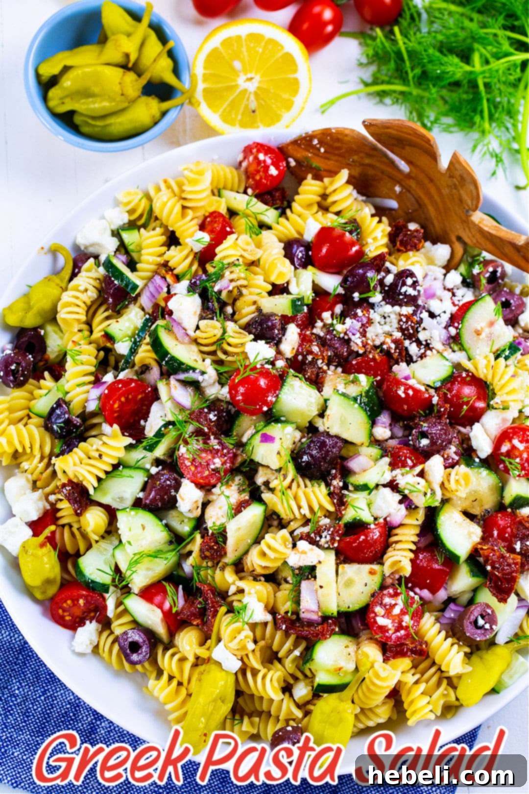 Zesty Greek Pasta Salad 5 Freshly mixed Greek Pasta Salad in a large mixing bowl, showcasing vibrant colors and textures.