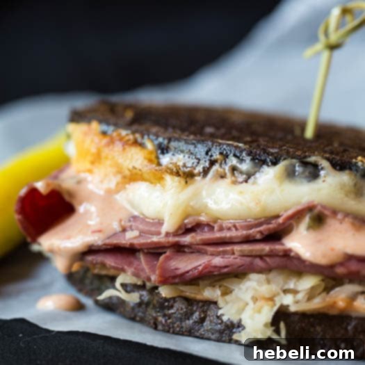 Reuben with a Kick 3 Close-up shot of the vibrant orange-hued spicy Reuben sauce, featuring a smooth, creamy texture, presented in a small white bowl on a rustic surface.
