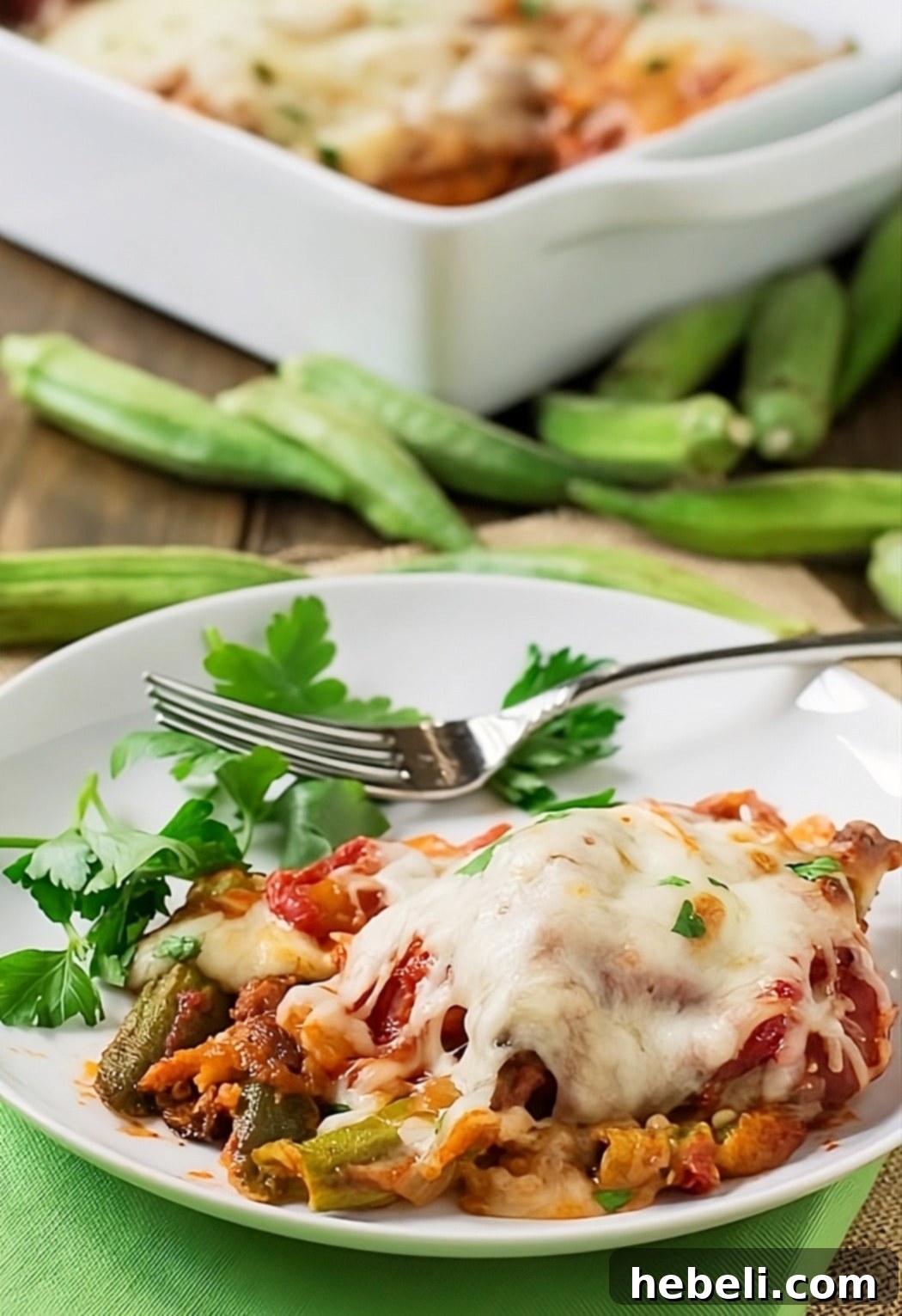 Classic Okra Parmigiana Bake 3 Finished Okra Parmigiana on a white plate, garnished with fresh herbs.