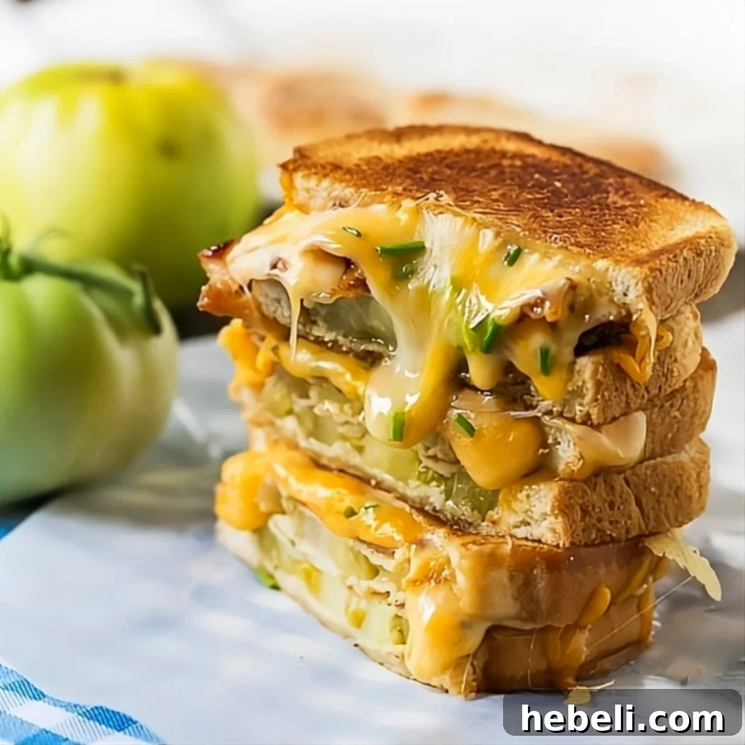 Perfectly halved Fried Green Tomato and Bacon Grilled Cheese sandwiches, showcasing the crispy exterior and gooey interior.