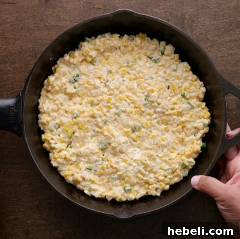 Transferring the mixed corn dip into a baking dish, ready for the oven.