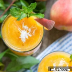 A refreshing Frozen Peach-Coconut Daiquiri in a hurricane glass, garnished with a peach slice and mint.