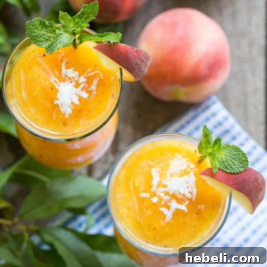 Tropical Peach Coconut Daiquiri 2 A close-up shot of a perfectly blended Frozen Peach-Coconut Daiquiri, garnished with fresh mint leaves, showcasing its smooth texture and refreshing appeal.