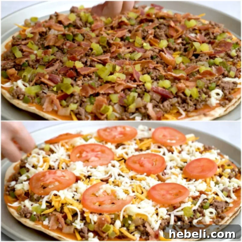 Fully topped cheeseburger pizza, ready for the oven, showing ground beef, bacon, pickles, and tomatoes over melted cheese.