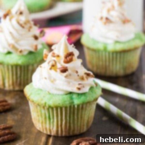 Watergate Cupcakes flavored with pistachio pudding and pineapple, topped with a delicious marshmallow fluff frosting.