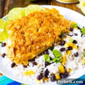 Tortilla Crusted Chicken with beans and rice on a white plate.