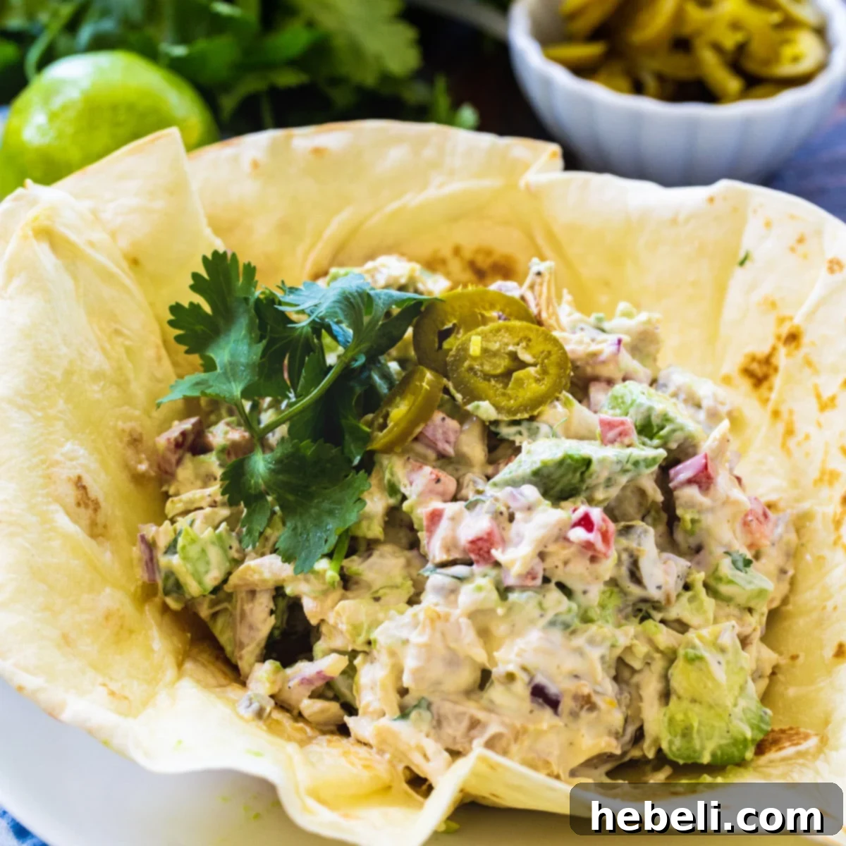 Bold Jalapeno Chicken Salad 2 Creamy Jalapeño Chicken Salad served elegantly in a golden, crispy tortilla shell, garnished with fresh cilantro.