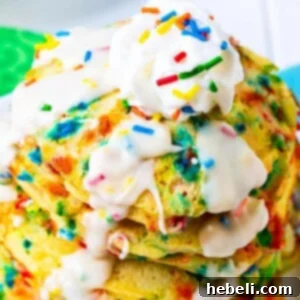 Stacked Cake Batter Pancakes with glaze and sprinkles