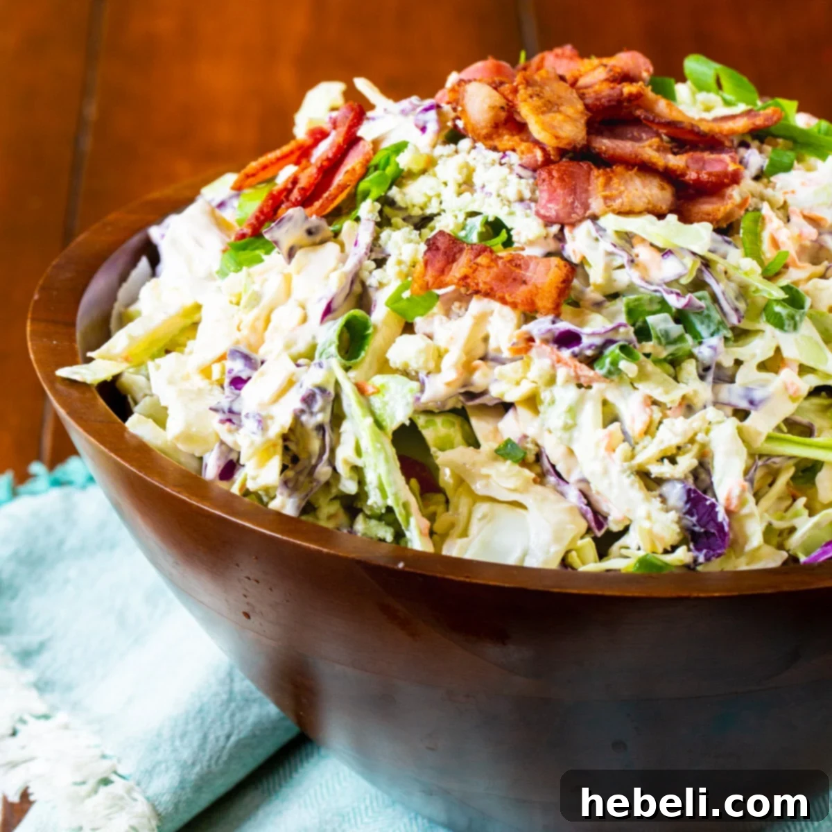 Tangy Blue Cheese Bacon Slaw 2 Blue Cheese Bacon Coleslaw in a large wooden bowl, showcasing its vibrant colors and inviting texture.